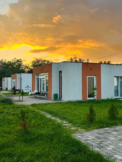 Котеджі Tur House ввечері, захід сонця над газоном