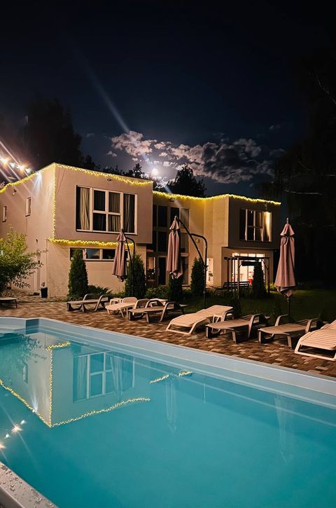 Корпус Tur House і басейн у вечірньому освітленні