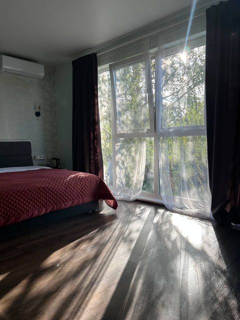 Номер Tur House з панорамним вікном і бордовим покривалом